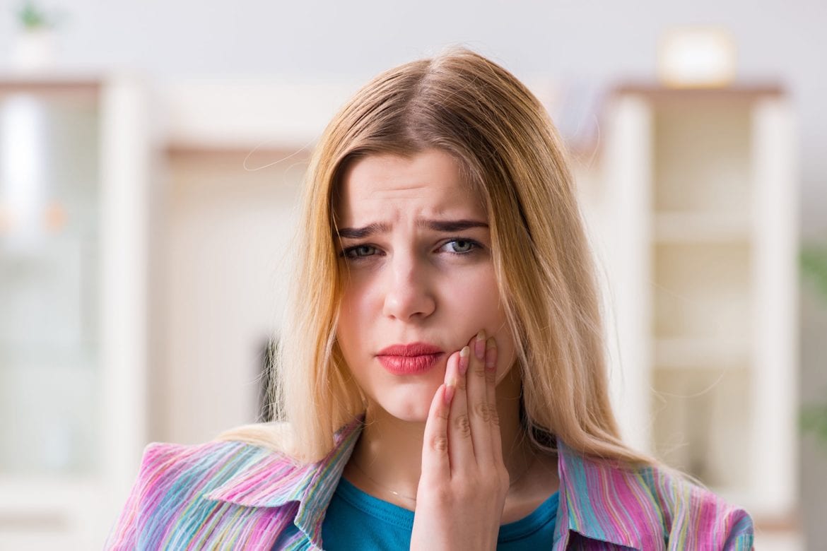 A woman is experiencing tooth pain