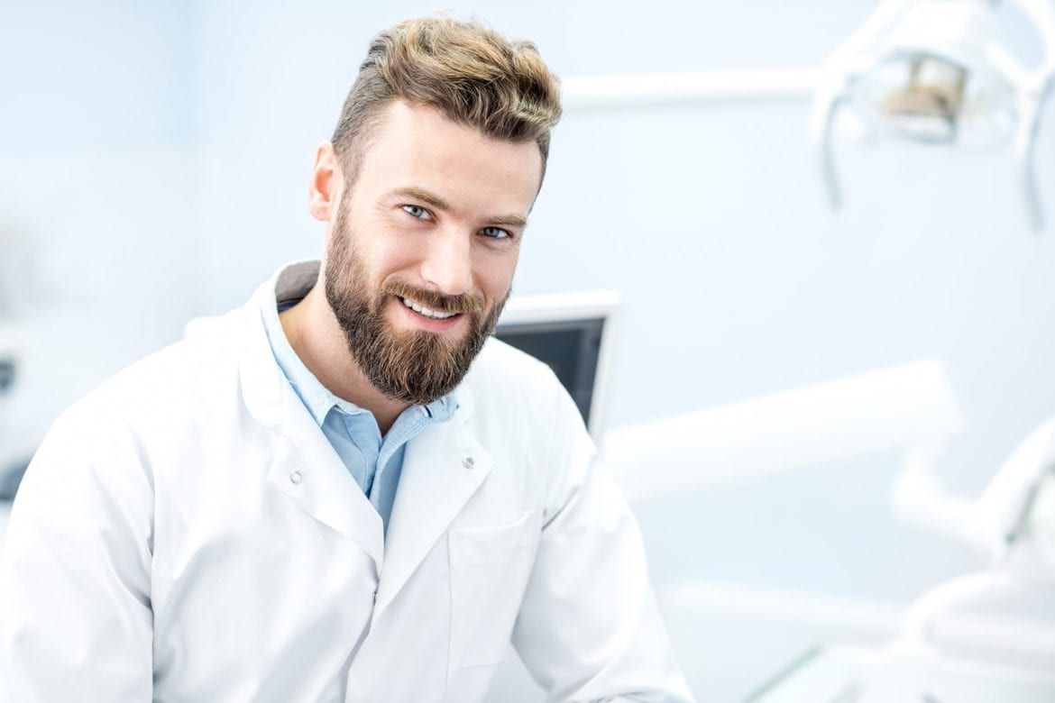 Dentist standing in front of dental chair