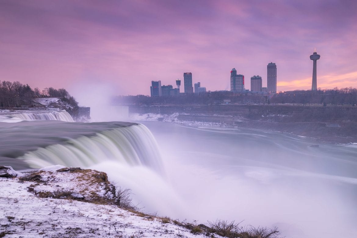 Water falls at dawn with the city skyline in the background