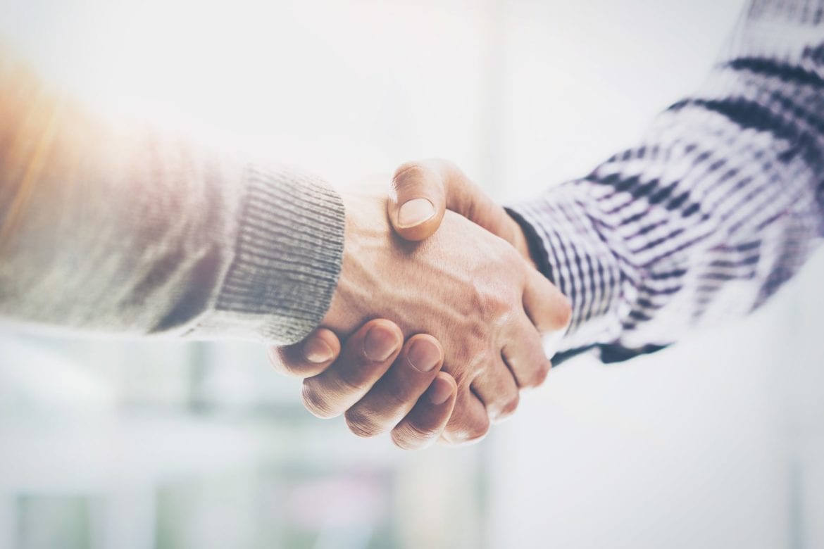 Two men are shaking hands in agreement