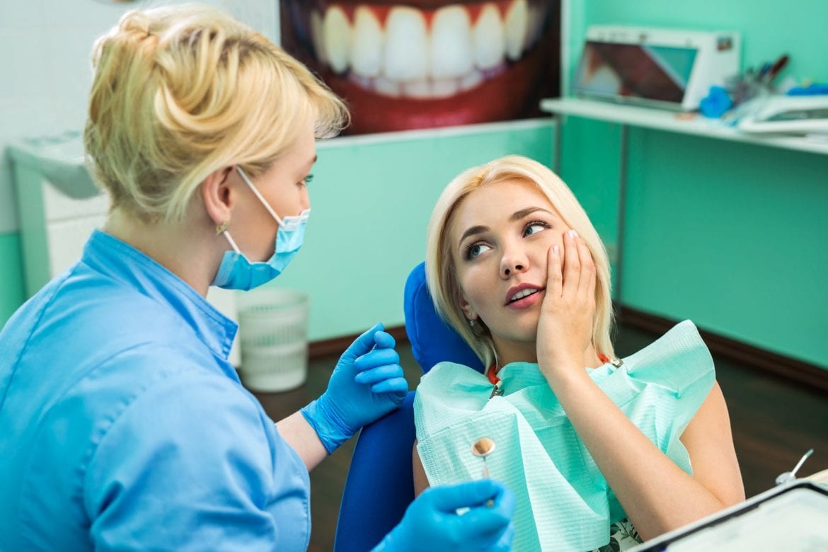 A woman speaking with her dentist about her tooth pain
