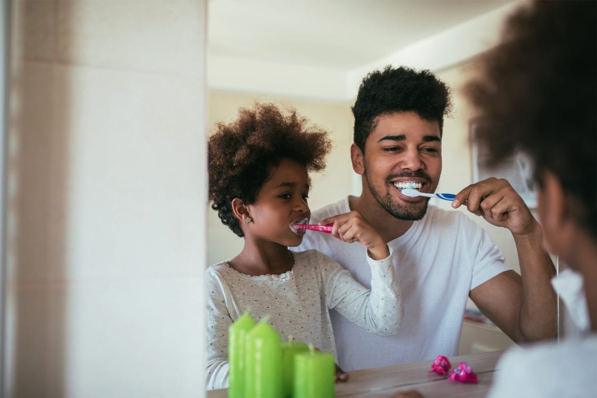 Father and son brushing their teeth in the bathroom
