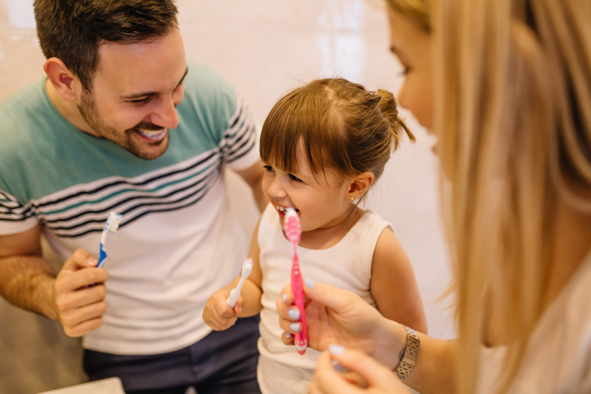 family brushing teeth together