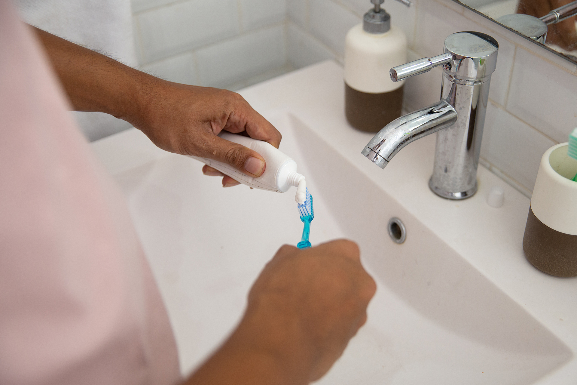 spreading tooth paste on a tooth brush