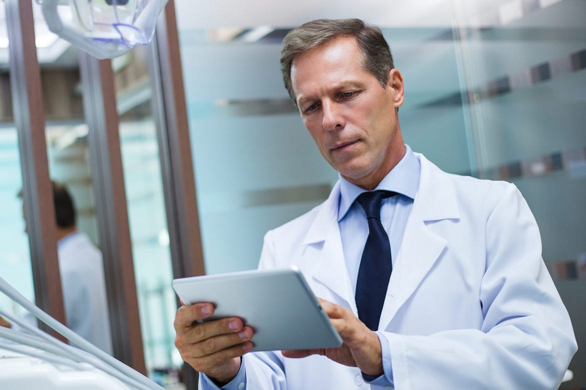 blog-eds-cybersecurity Dentist holding an electronic tablet