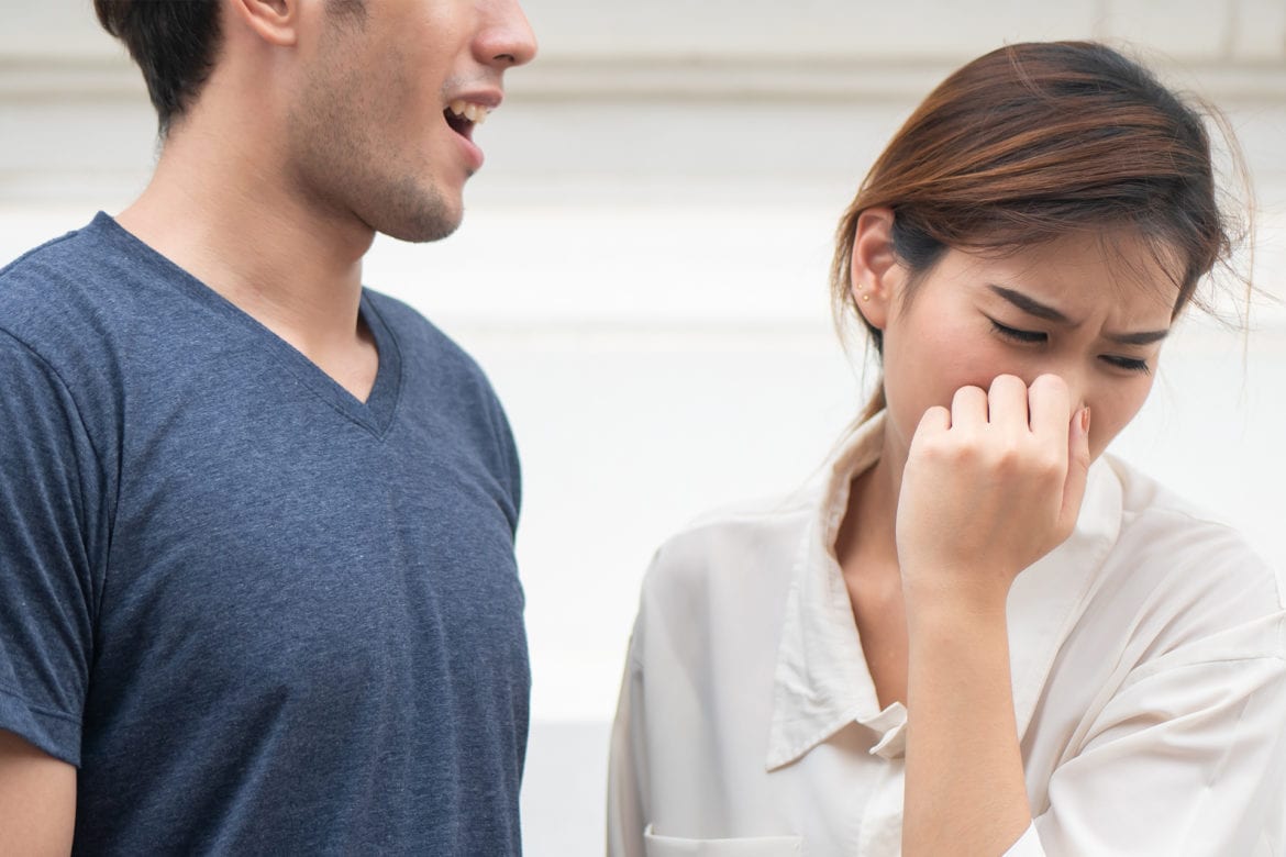 Male with bad breath speaking to woman
