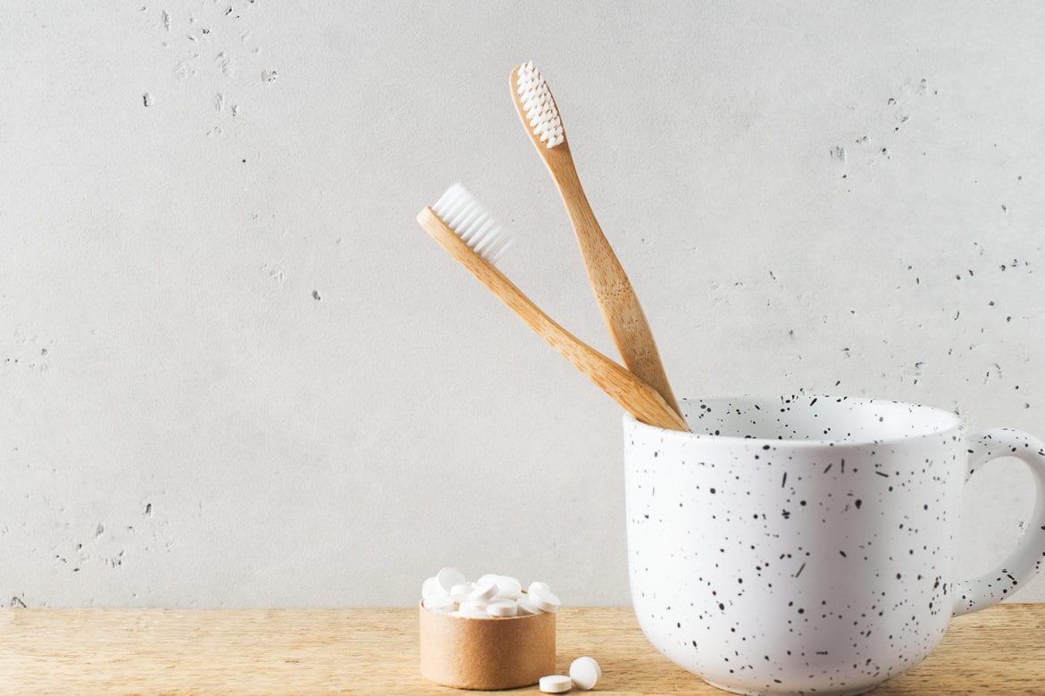 blog-eds-toothpastePILLS Toothpaste pills next to two tooth brushes in a white cup