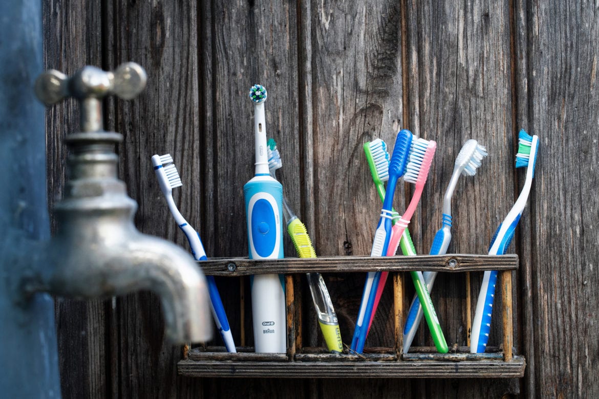 A row of toothbrushes next to a bathroom sink