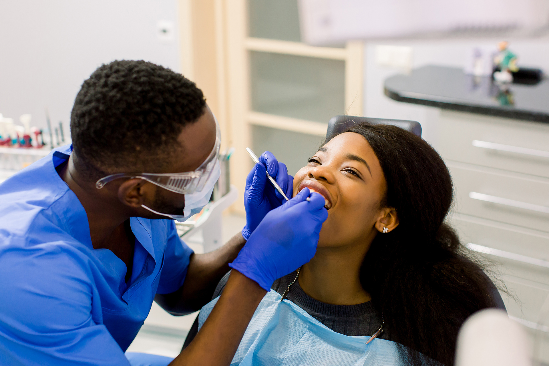 A male dentist is treating his female patient