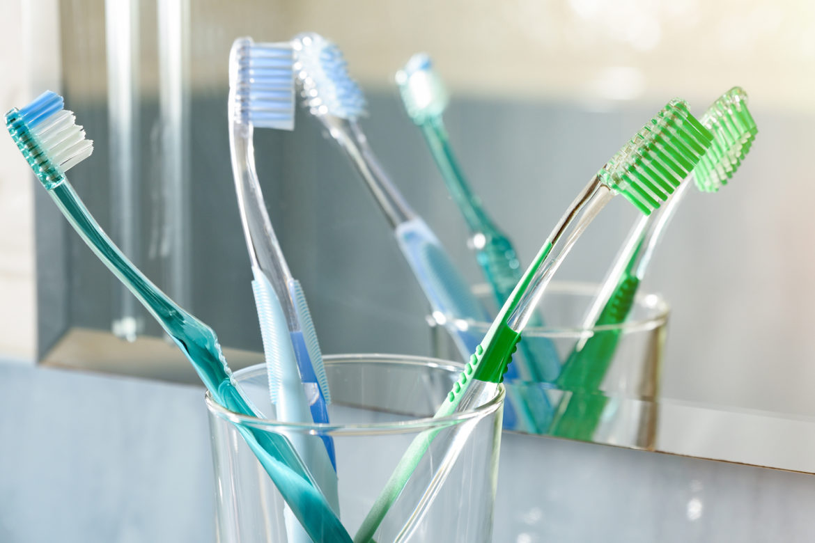 Tooth brushes sitting in transparent cups