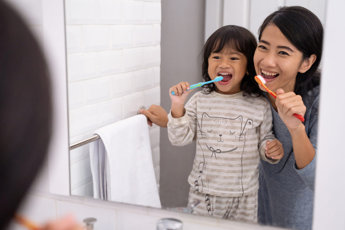 Mother and daughter brushing teeth in the bathroom