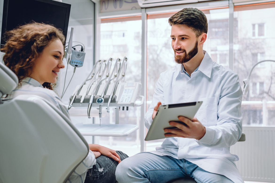 dentist showing a tablet device to a female patient