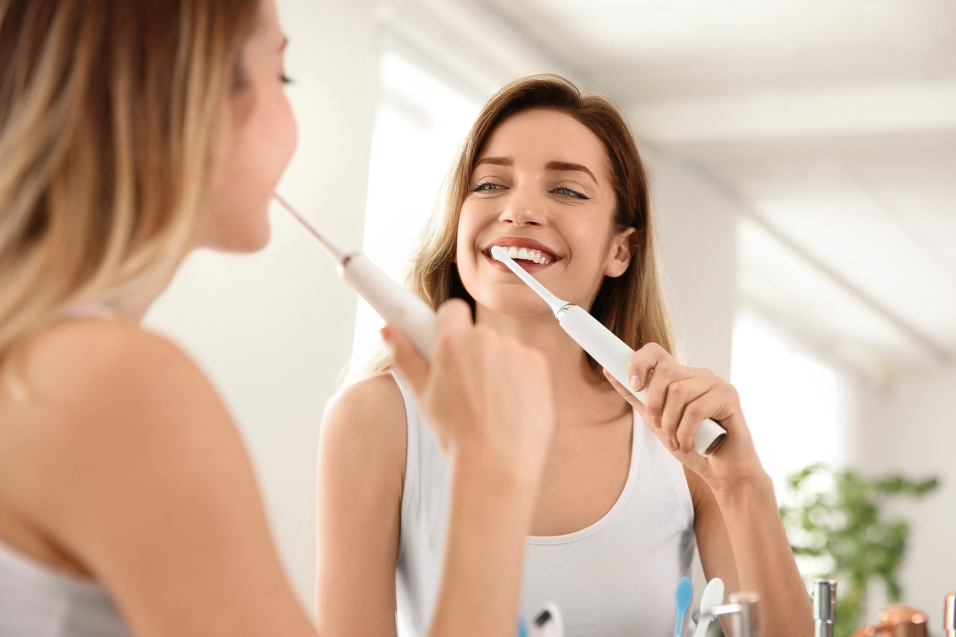 woman using an electric tooth brush
