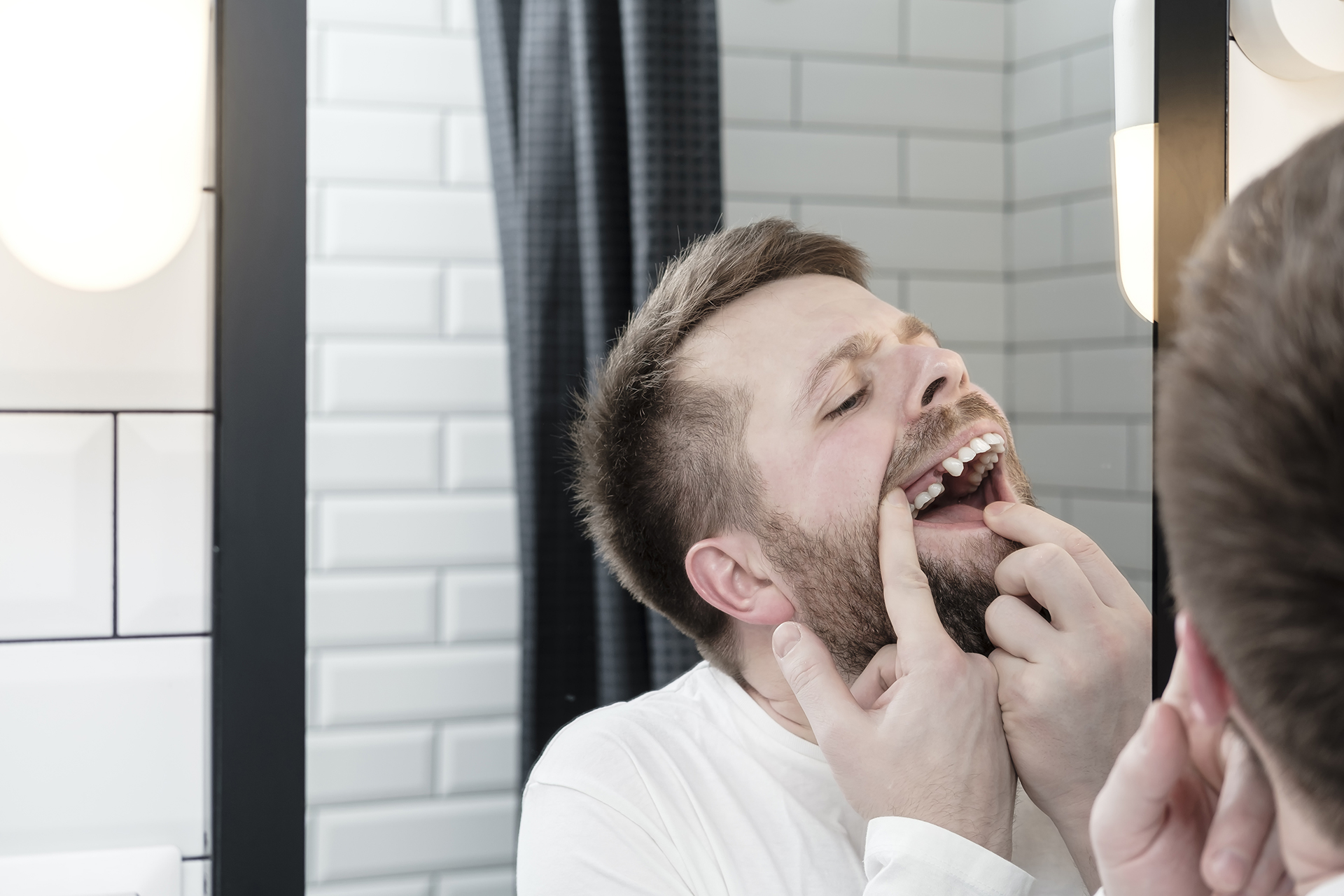 man examining his teeth