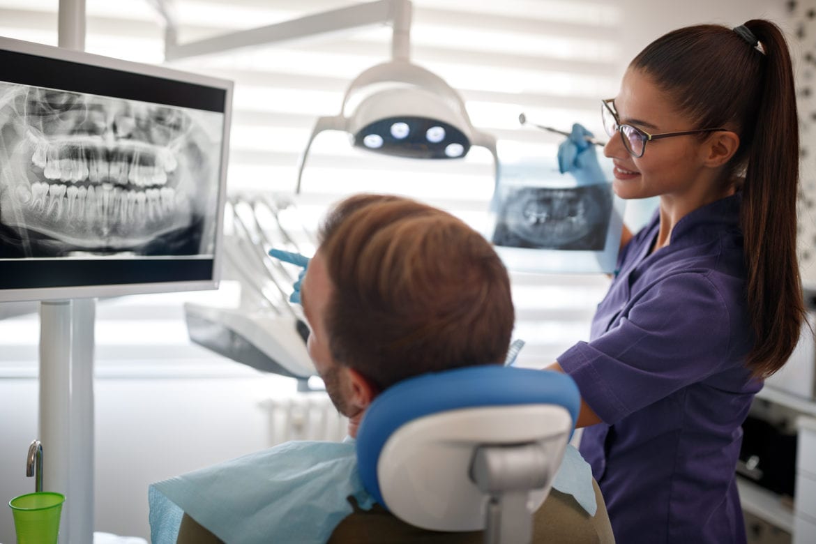 blog-eds-regularservice dentist showing a patient tooth x-rays
