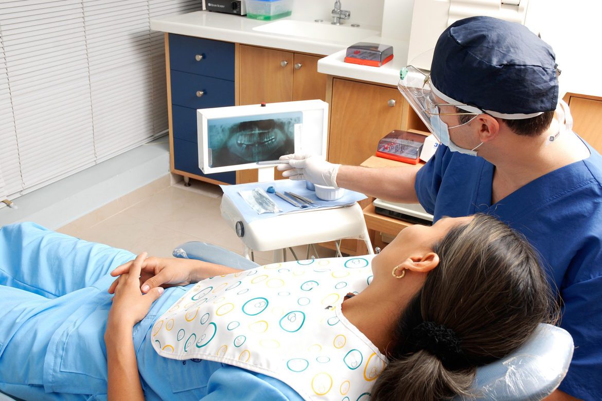 dentist and patient looking at tooth x-rays