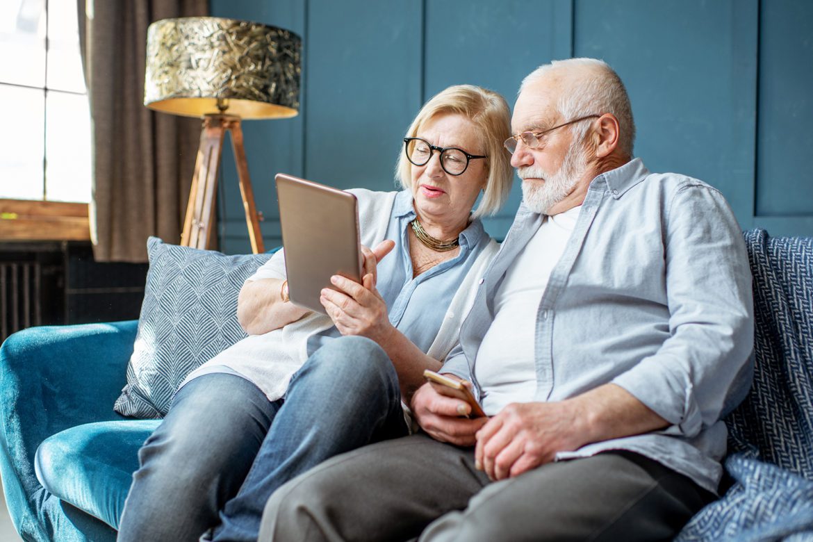 Elderly couple reading a document while sitting down