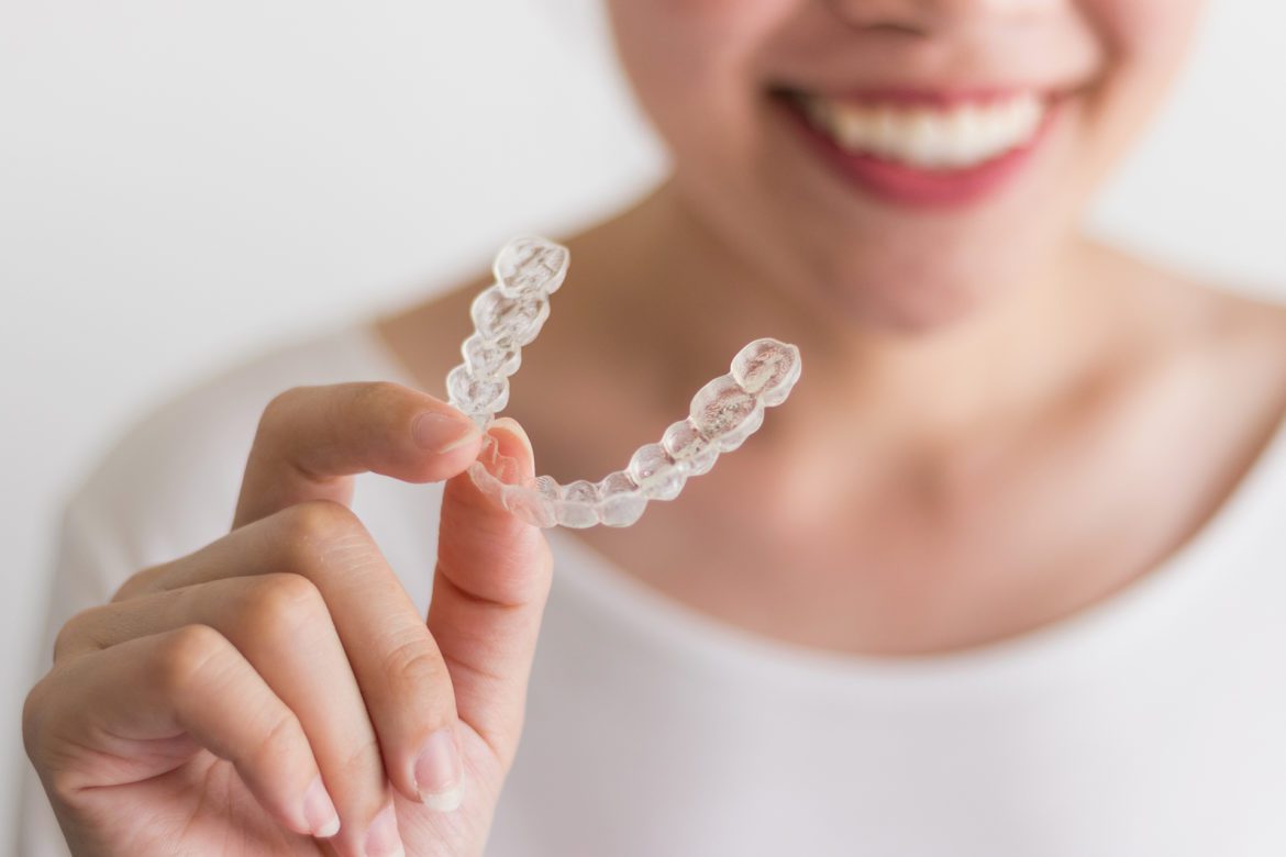 Woman holding an invisible aligner