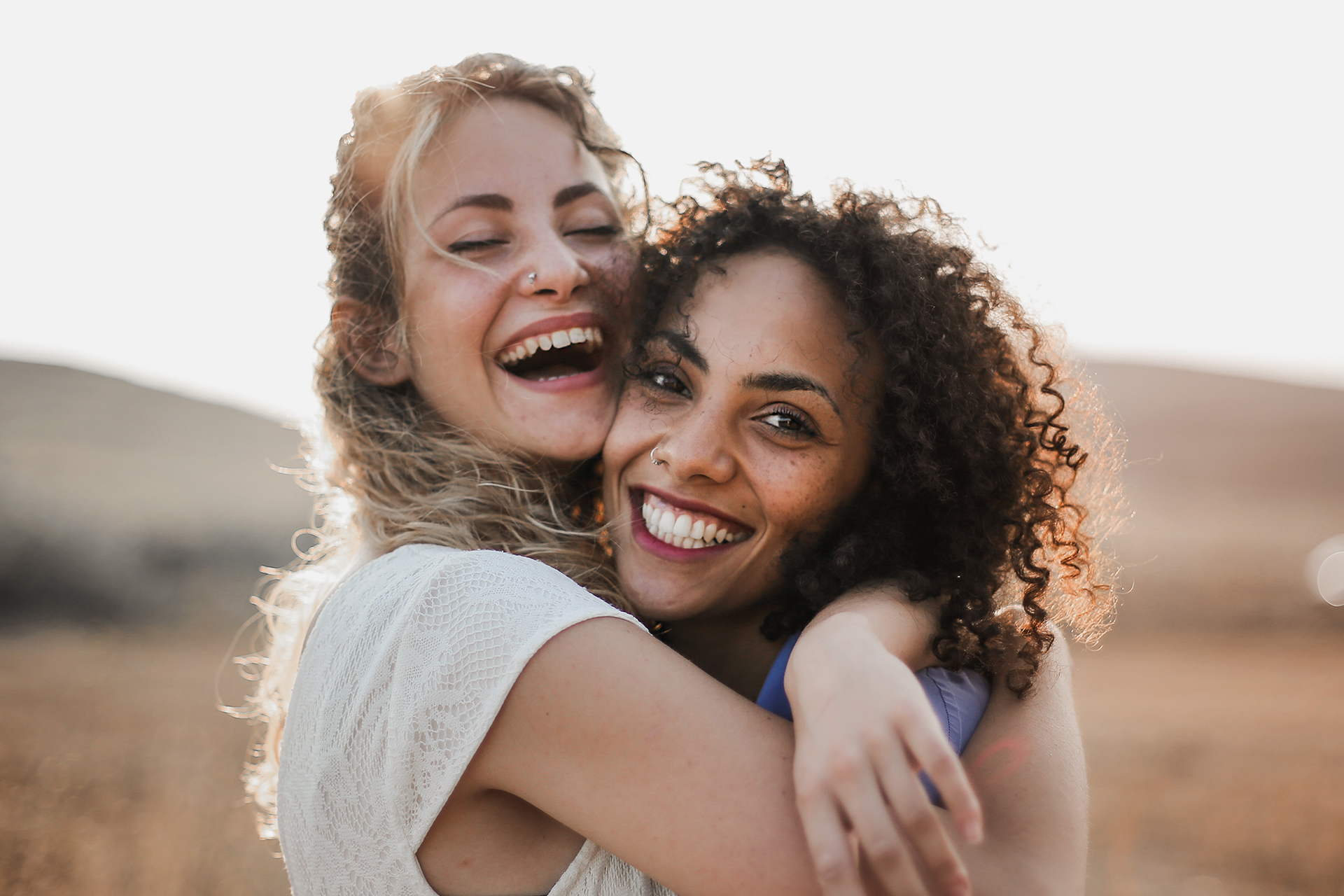 Two women are smiling and hugging.