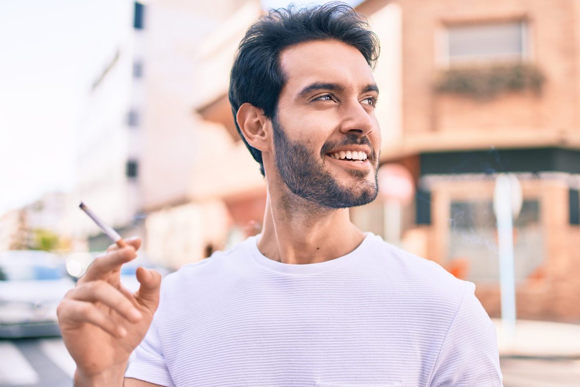 blog-eds-badDentalhabits Man holiding ciggorette in front of building