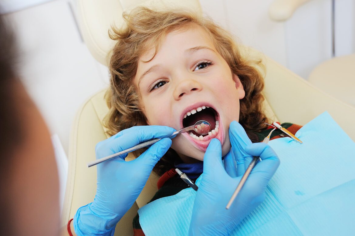 blog-eds-kidsfirstvisitdent A little girl getting her teeth examined by a dentist