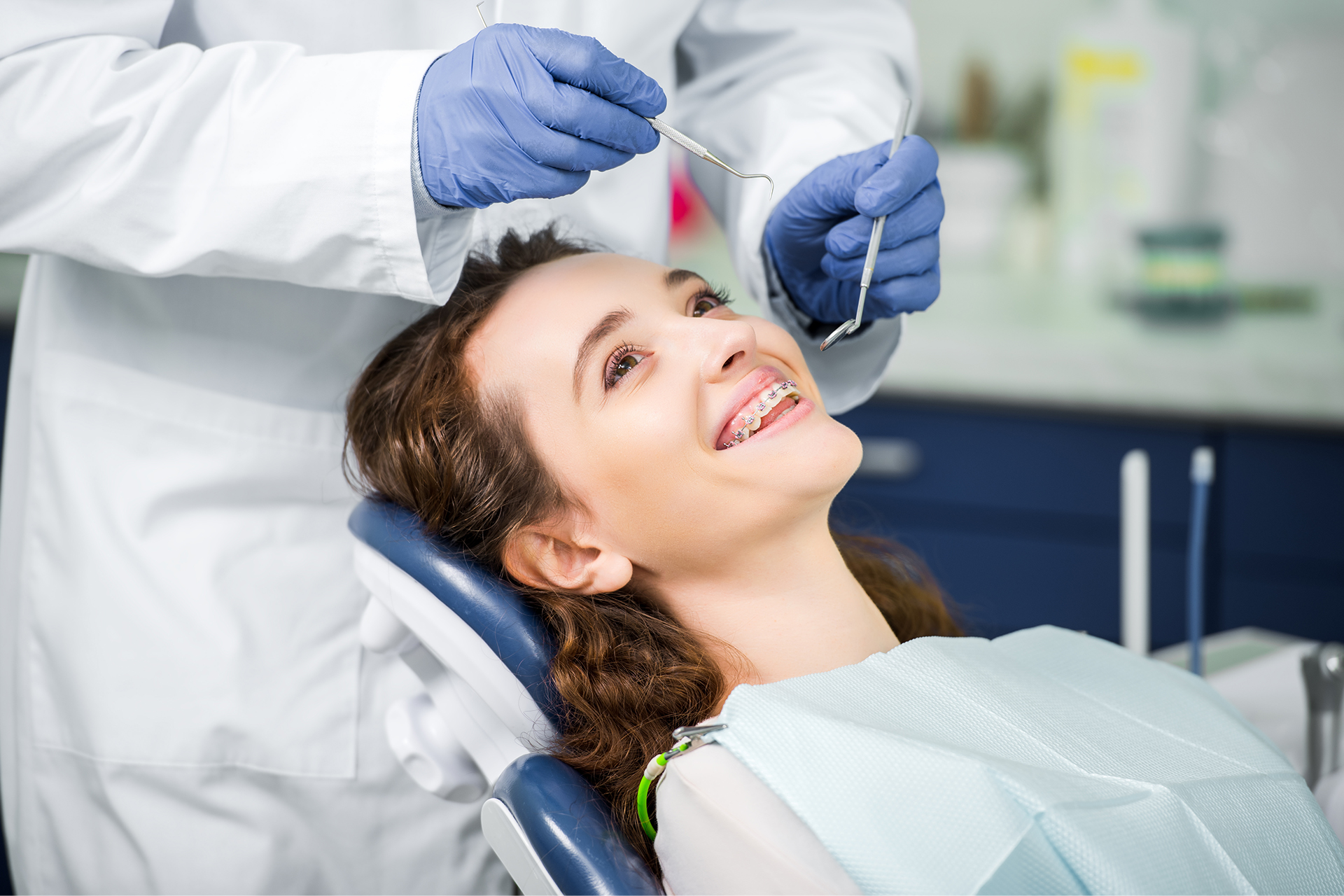 woman sitting in a dental chair in front of a dentist